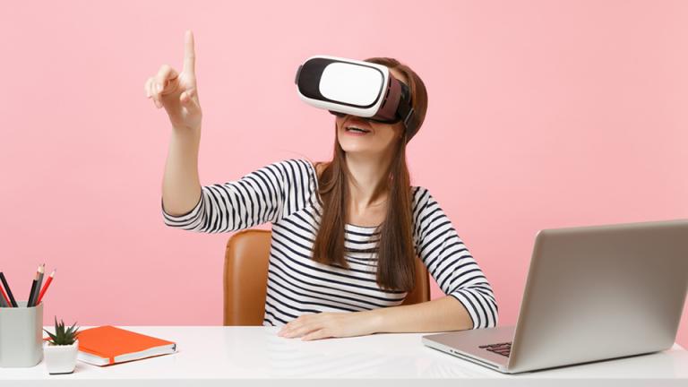Alumna con laptop y visor de realidad virtual