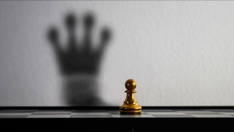 Peón de ajedrez, proyectando una sombra de rey