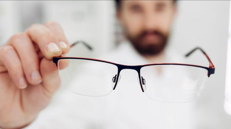 Oftalmólogo ofreciendo anteojos para miopía